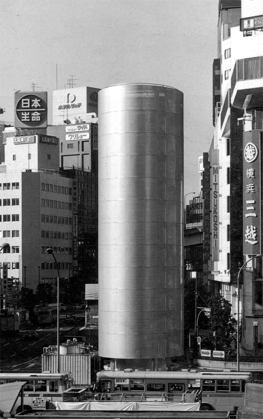 La Torre de los Vientos de día: un cilindro de aluminio entre los edificios de Yokohama