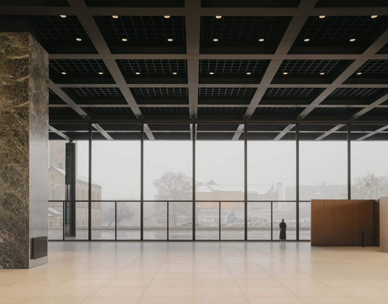 Interior de la Neue Nationalgalerie con vista a la ciudad en la niebla