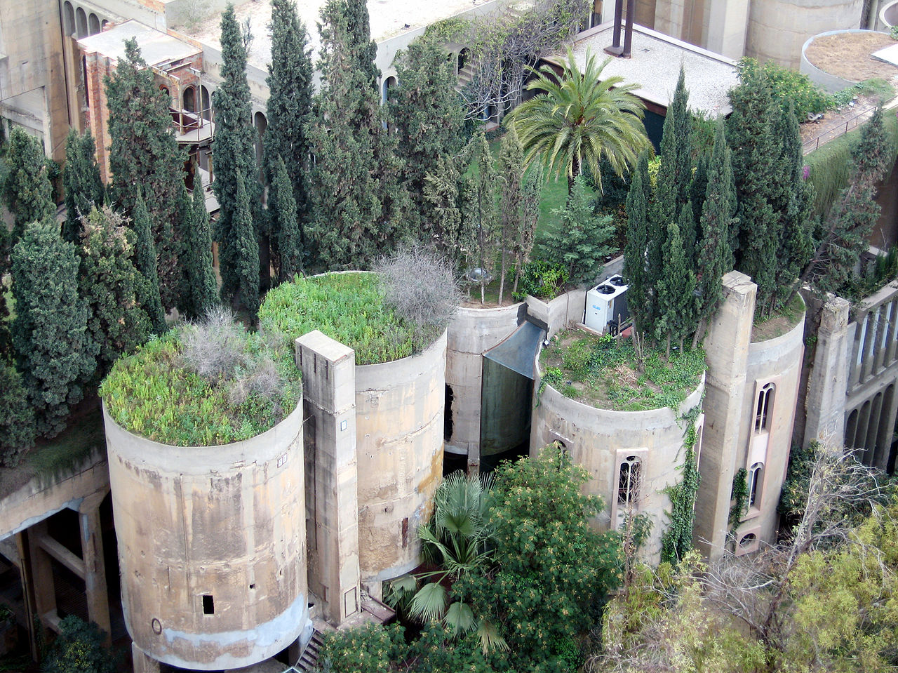 Vista aérea de La Fábrica: silos de hormigón entre cipreses y jardines