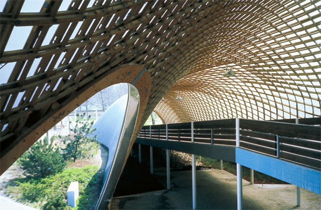 Pasarela bajo la retícula curva de madera del Multihalle de Mannheim