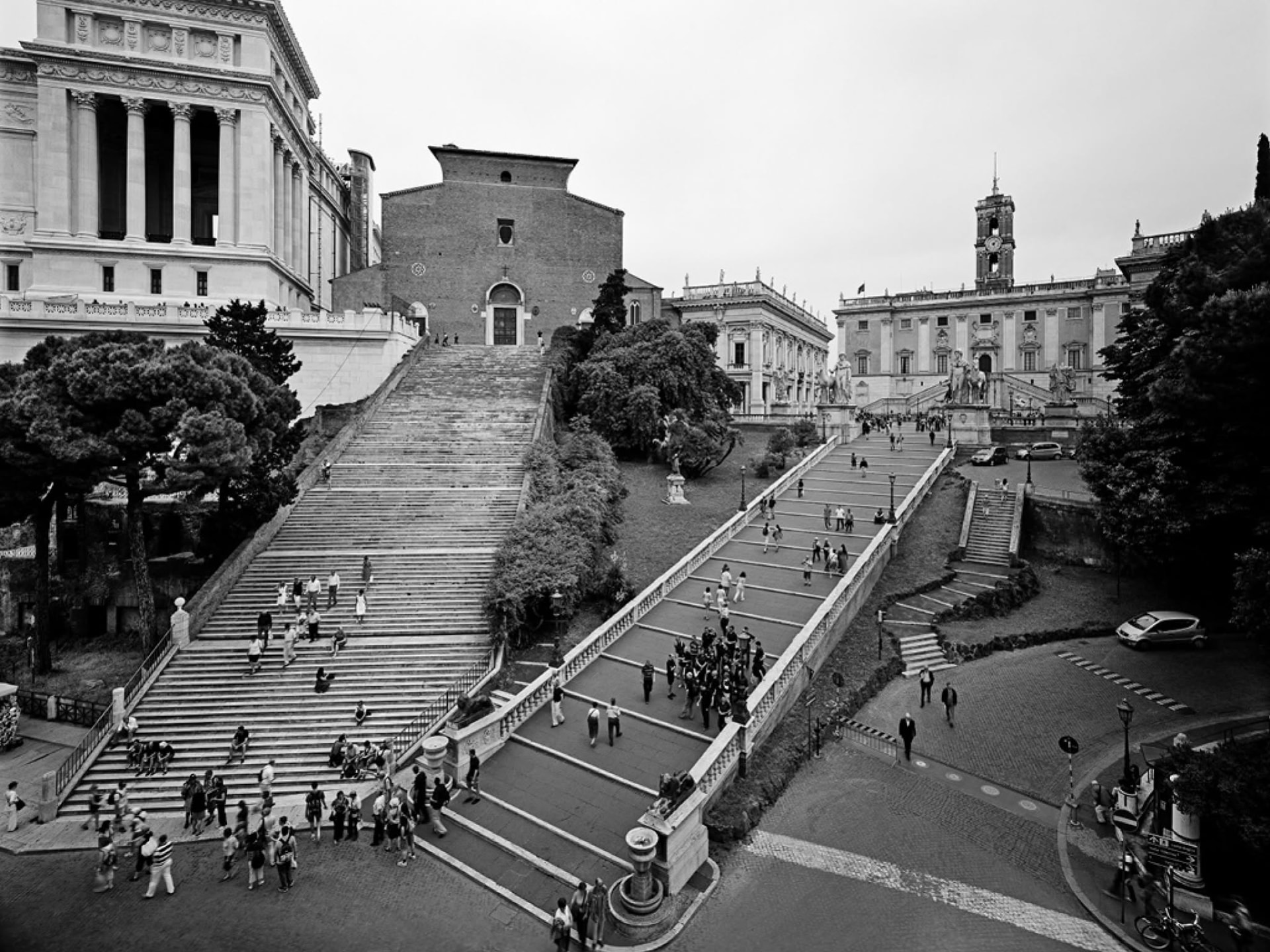 Vista en blanco y negro de la escalinata del Campidoglio en Roma, con gente subiendo